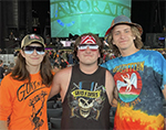 3 men posing for a photo infront of a stage